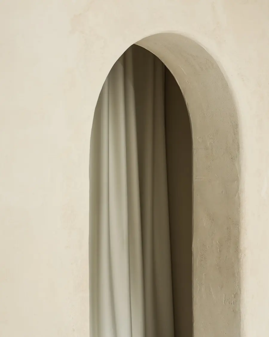 Soft plaster archway and linen drape inside the clinic