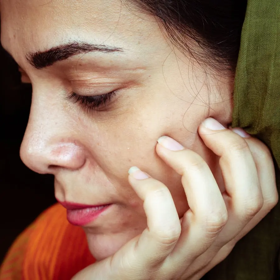 Woman resting her hand against her cheek in soft, warm light