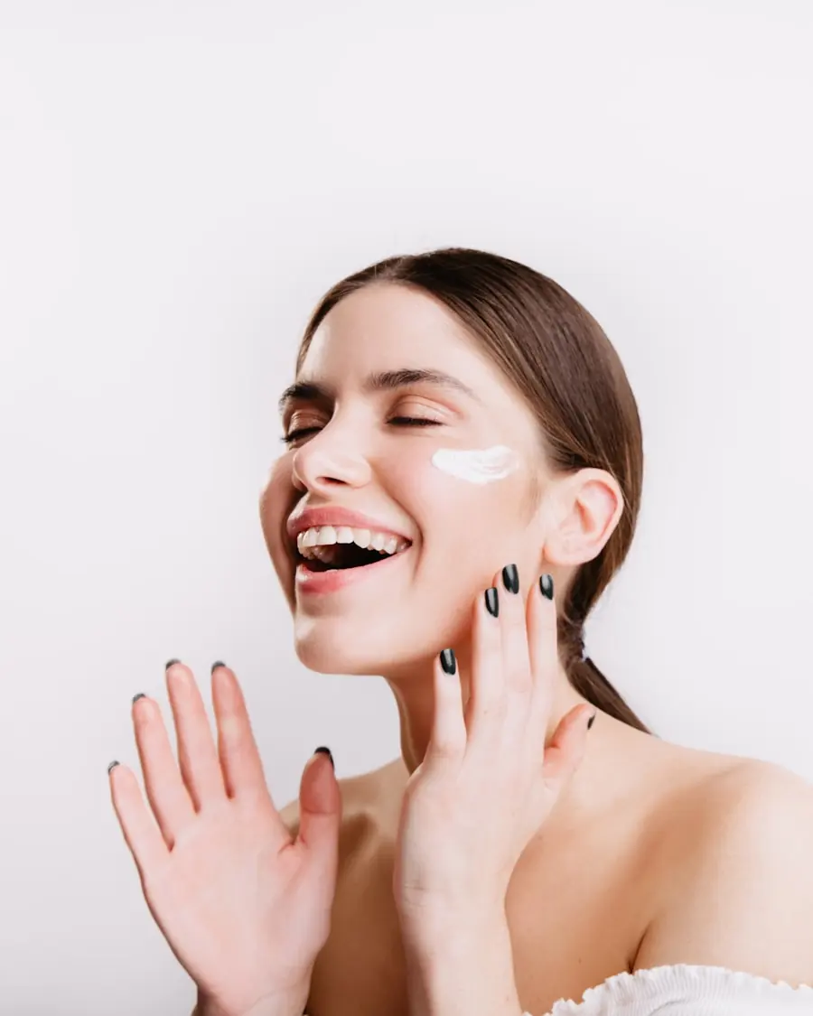 Woman smiling with brightening treatment cream applied to her cheek